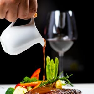 Succulent steak served with vegetables and red wine, topped with a rich sauce.