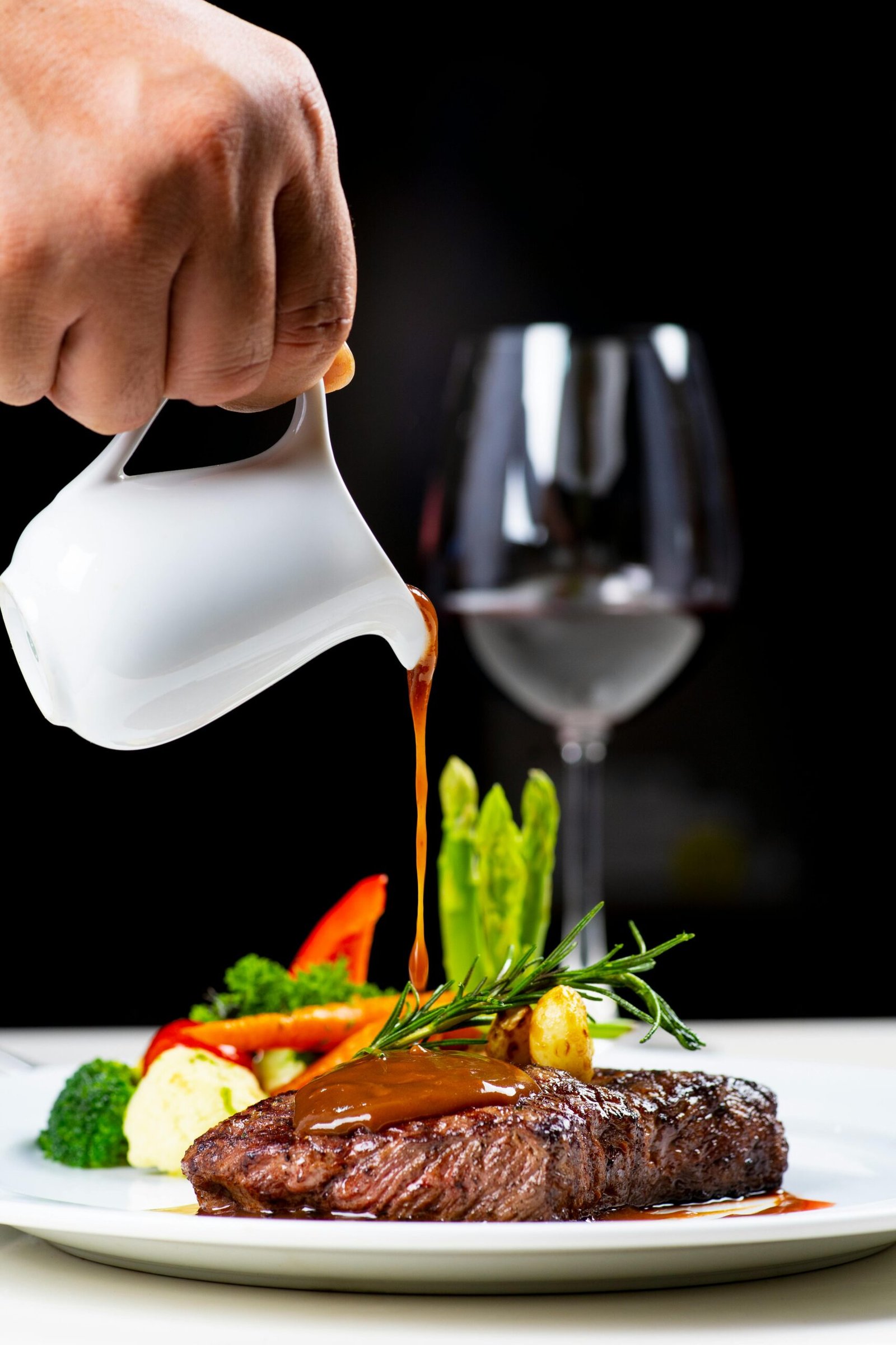 Succulent steak served with vegetables and red wine, topped with a rich sauce.